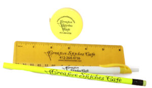 Promotional items for Creative Stiches, ruler, pen, pencil, and soft tape measure.